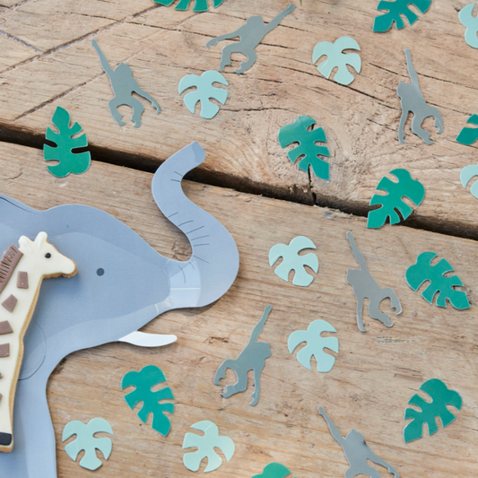 Table setting with elephant shape plate. Table confetti mix of leaf and hanging monkey.