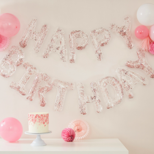 Clear foil with pink confetti Happy Birthday Banner.  12 individual letters hanging on clear twine. 